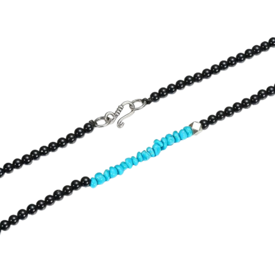 Detailed view of the handcrafted sterling silver bead and raw Tibetan turquoise chips on the Quiet Dawn necklace.