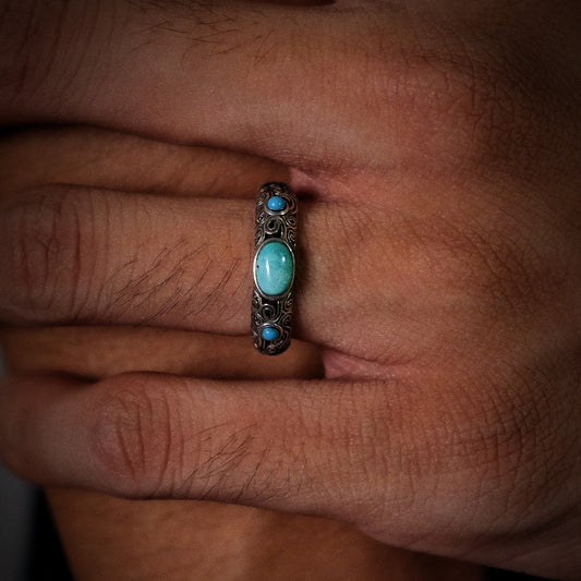 Close-up of a model's hand wearing the oxidized Eternal Scroll ring, highlighting its antique texture.