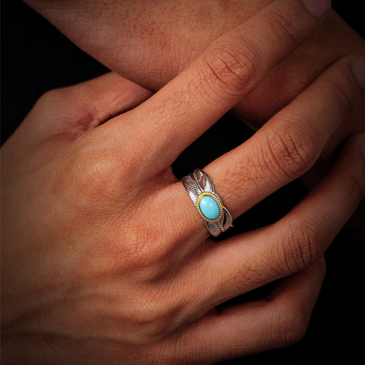 Close-up of a model's hand wearing the bold oxidized silver wing wrap ring for spiritual protection.