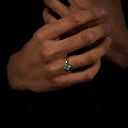 Close-up of a model's hand wearing the adjustable silver Mandala ring against a dark background.