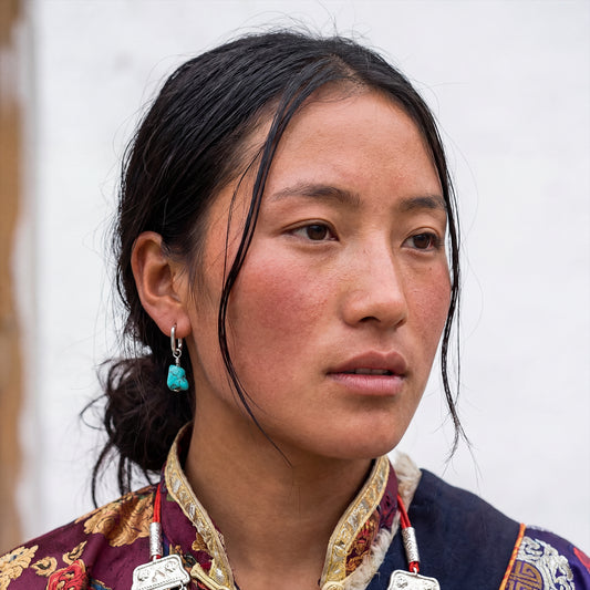 Portrait of a woman wearing the Raw Drop Tibetan turquoise earrings for spiritual grounding and natural style.