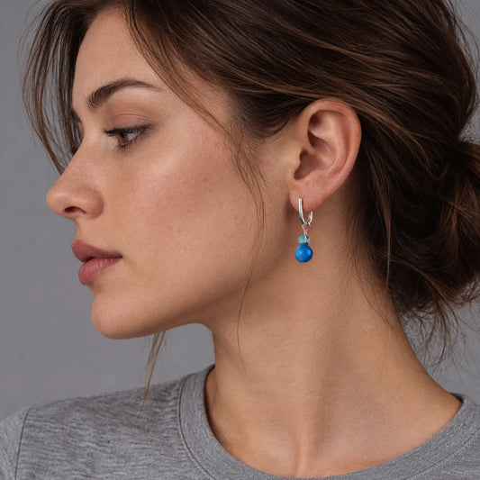 Side profile of a model wearing the Serene Drops turquoise sphere earrings for a peaceful look.