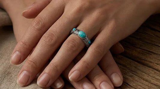 A woman resting her hands while wearing a genuine turquoise ring, showing how natural stone texture can support a personal grounding ritual.
