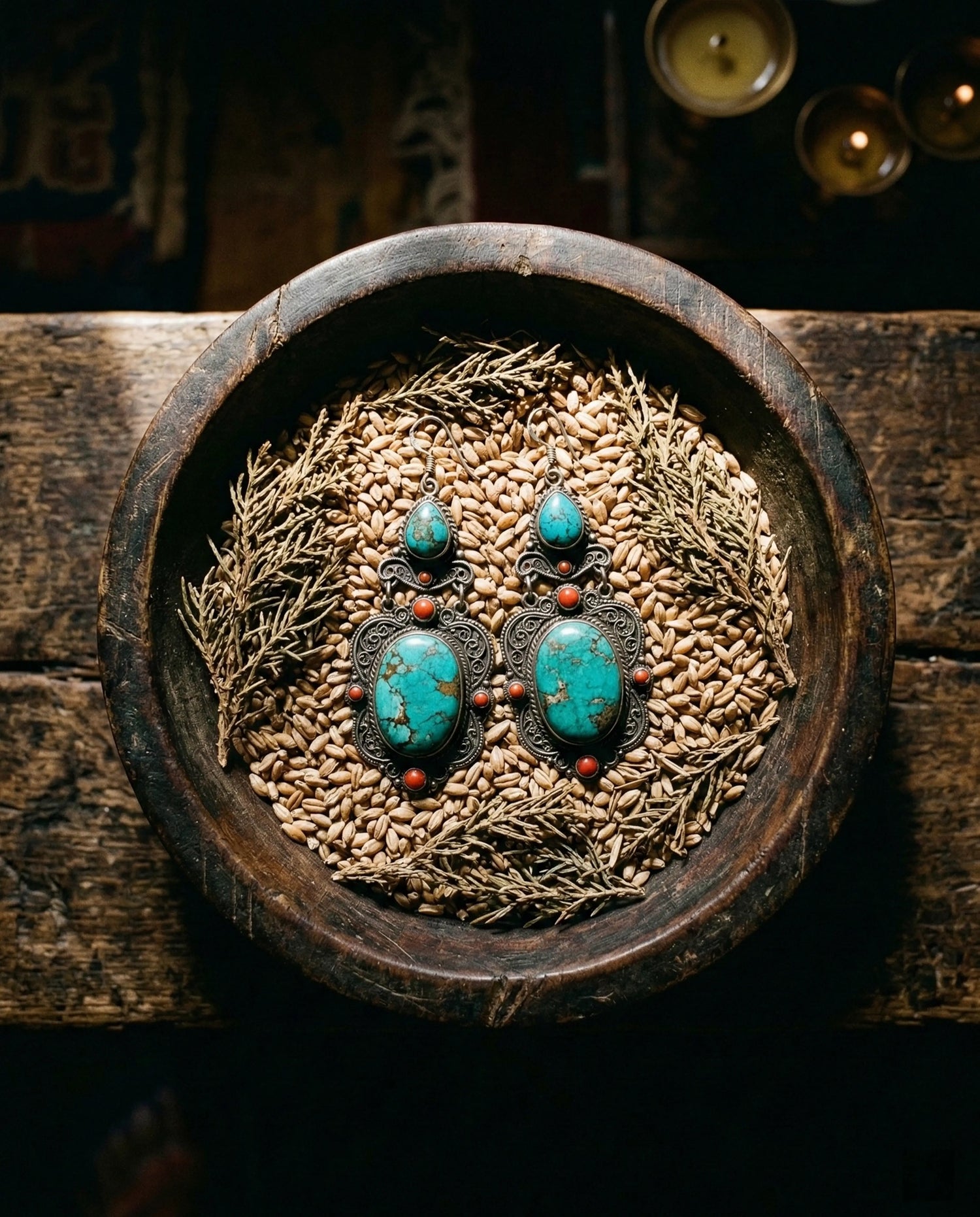 A pair of vibrant Tibetan turquoise drop earrings resting inside a rustic bronze offering bowl, symbolizing abundance and the Fulfillment Collection.