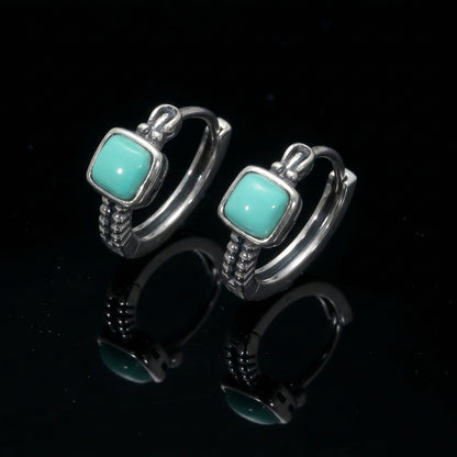 The Axiom Hoops featuring square-cut Tibetan turquoise and architectural sterling silver textures.
