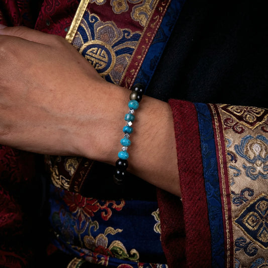 Close-up of a model's wrist wearing the Eclipse protection bracelet with traditional embroidered attire.