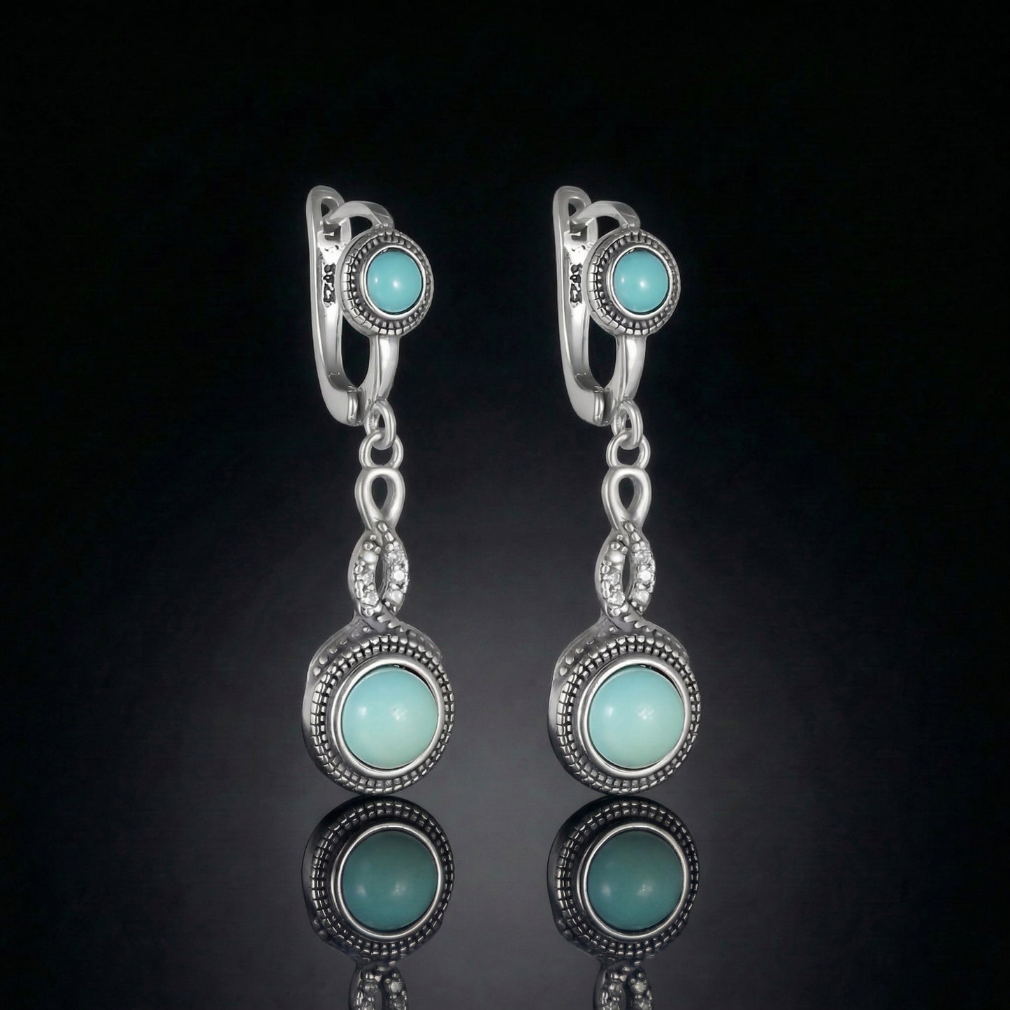 The Eternal Drops featuring dual round Tibetan turquoise stones and vintage-inspired silver milgrain halos.