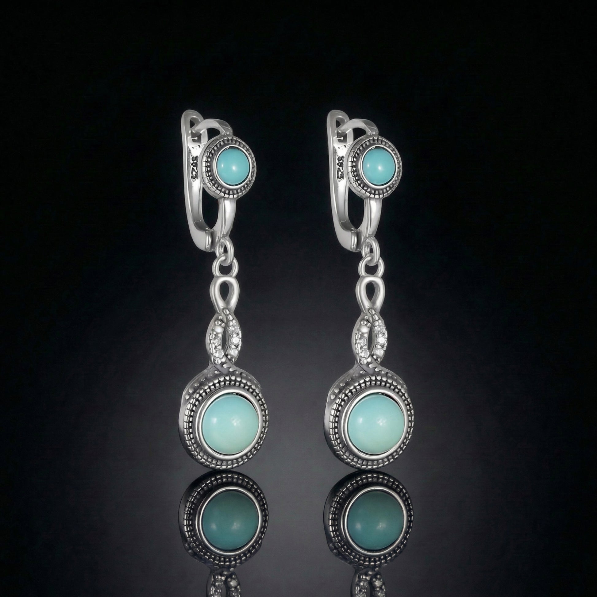 The Eternal Drops featuring dual round Tibetan turquoise stones and vintage-inspired silver milgrain halos.