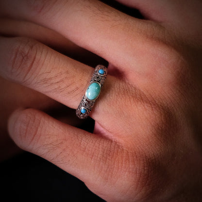 Perspective view of the Eternal Scroll turquoise ring on a finger, showcasing its substantial silver presence.