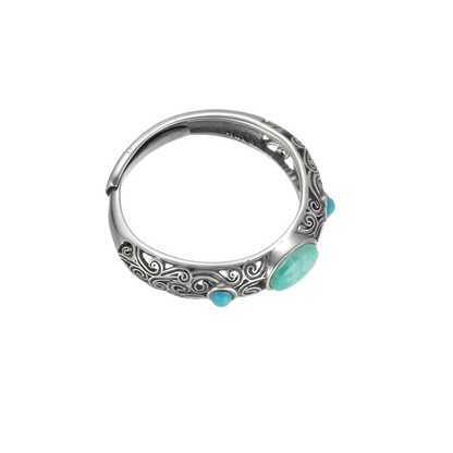 Angled view of the Eternal Scroll ring on white background, focusing on the three turquoise stones and carvings.