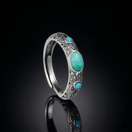 The Eternal Scroll Ring featuring deeply oxidized silver scrollwork and a triad of Tibetan turquoise stones.