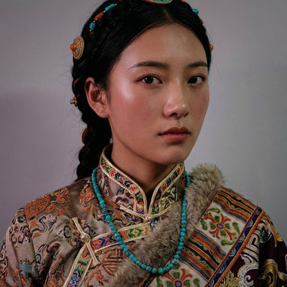 Portrait of a woman in traditional attire wearing the natural turquoise chip necklace for spiritual grounding.