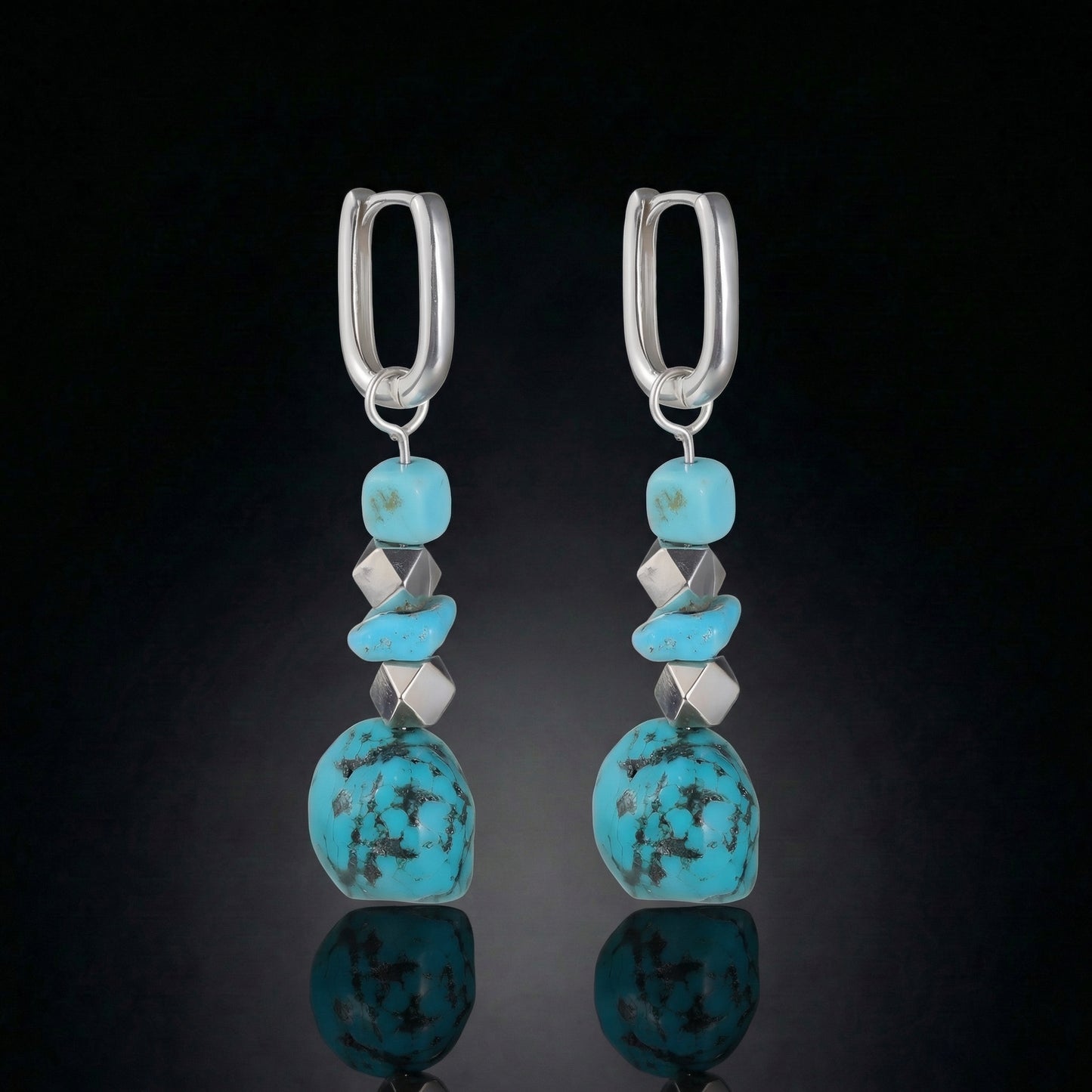 The Grounding Drops featuring a cascade of Tibetan turquoise nuggets, silver cube spacers, and U-shaped silver hoops.