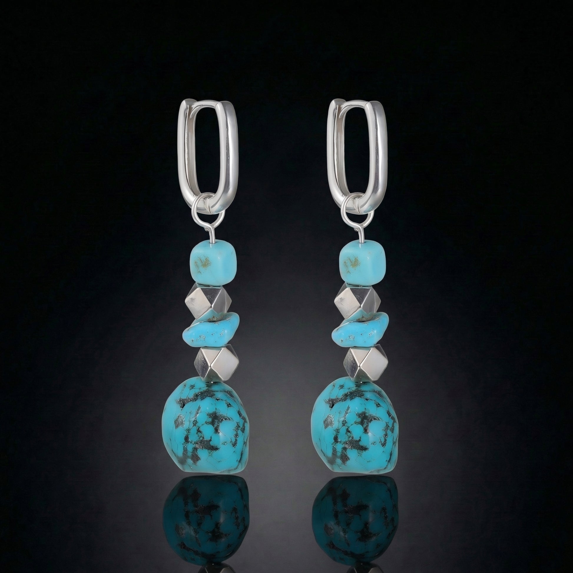 The Grounding Drops featuring a cascade of Tibetan turquoise nuggets, silver cube spacers, and U-shaped silver hoops.