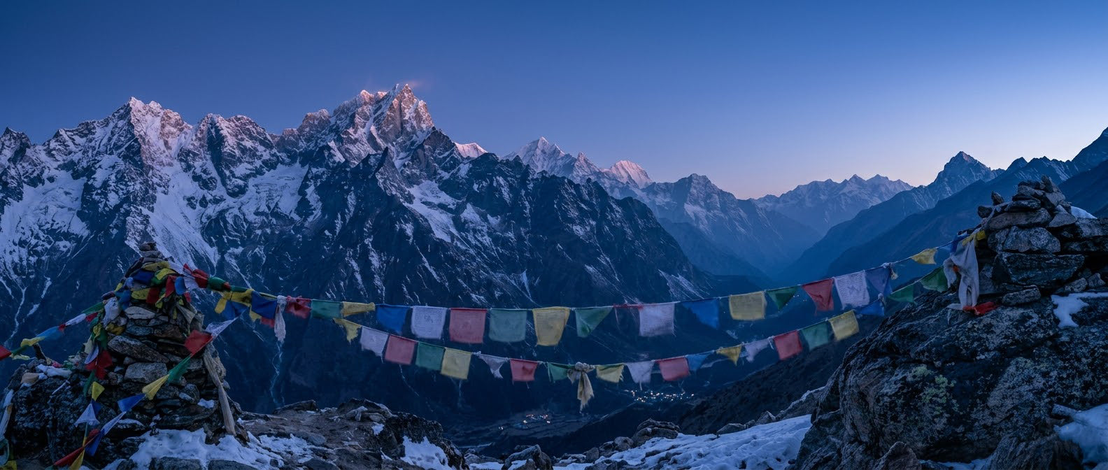 A breathtaking view of snow-capped Himalayan peaks under a dramatic, moody sky at golden hour. Colorful, tattered Tibetan prayer flags whip in the strong wind across the majestic mountain landscape, evoking a sense of spiritual peace and the raw, authentic beauty that inspires Tashi Turquoise.