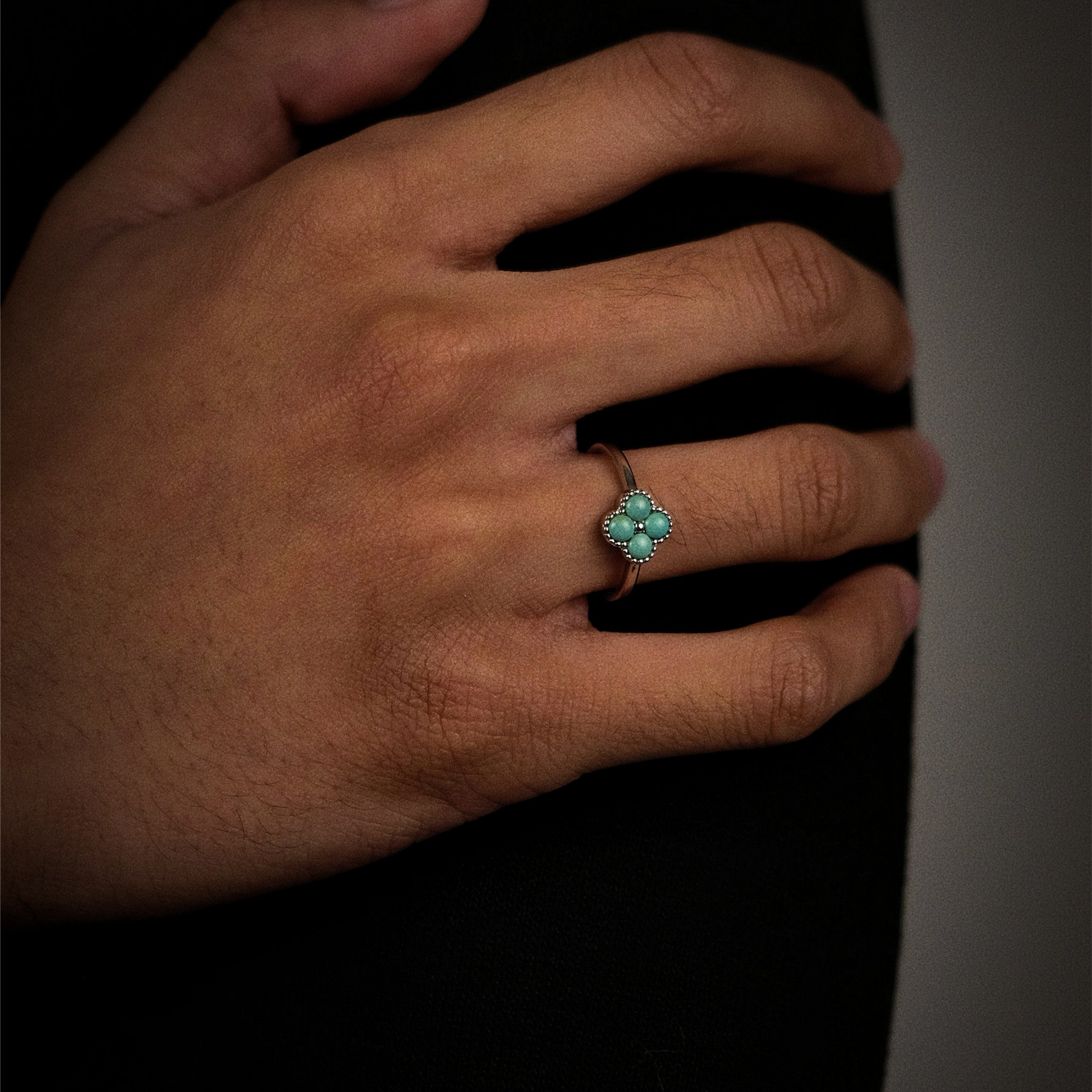 Perspective view of the Tibetan turquoise Mandala ring on a finger, showcasing its sacred geometry.