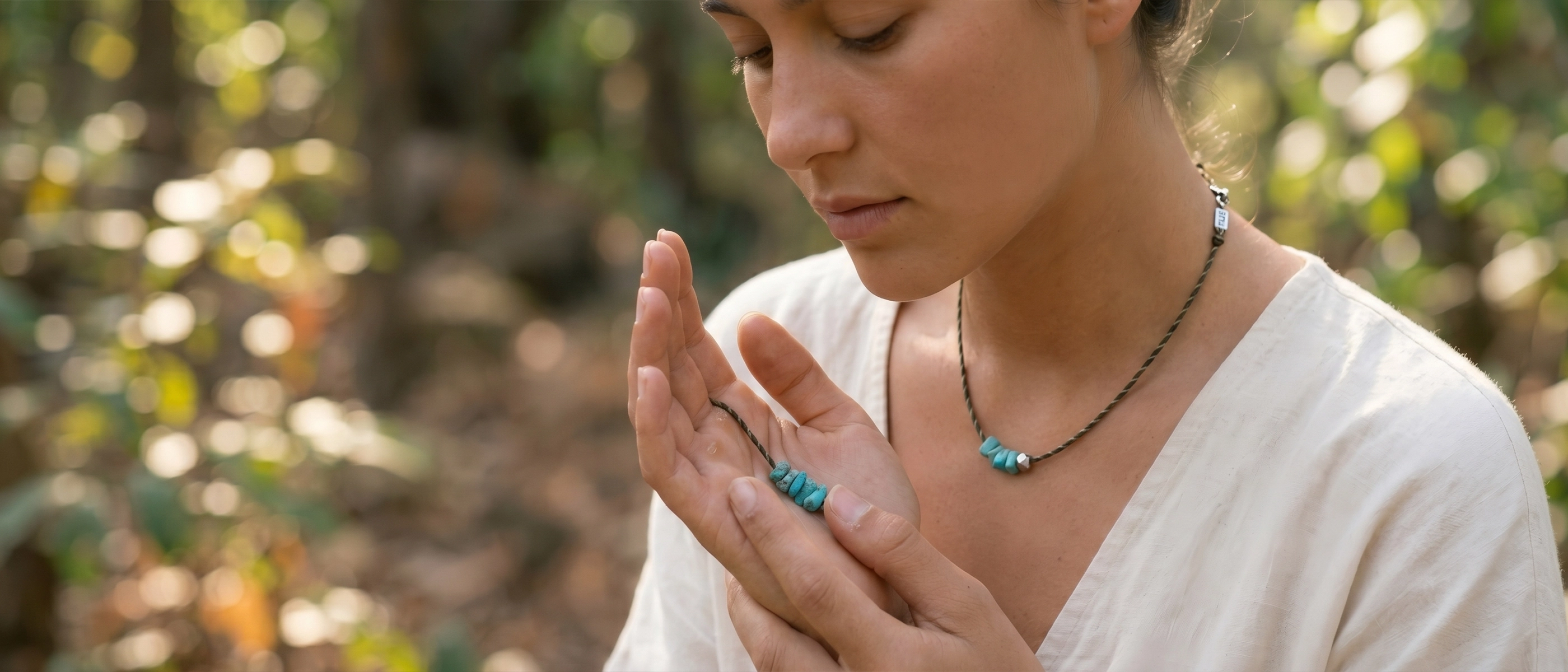 A serene woman finding peace in nature while holding a raw turquoise necklace. Discover how to choose a jewelry gift with deep meaning for mom through our collection. These unique jewelry gifts for mom serve as perfect mindful gifts for her and are deeply aligned as spiritual mothers day gifts.