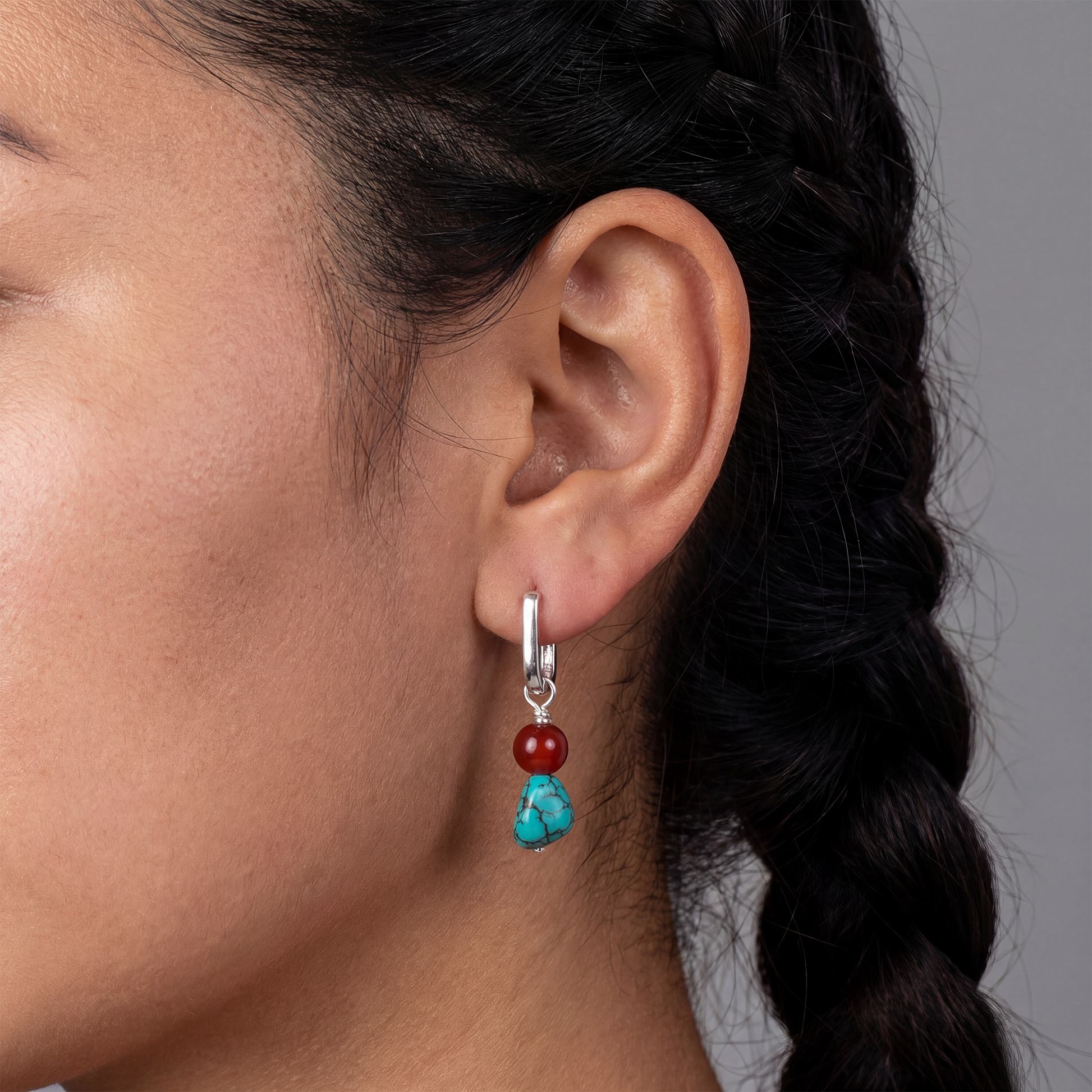 Close-up profile of a model wearing the Abundance Drops Tibetan turquoise earrings for spiritual completeness.