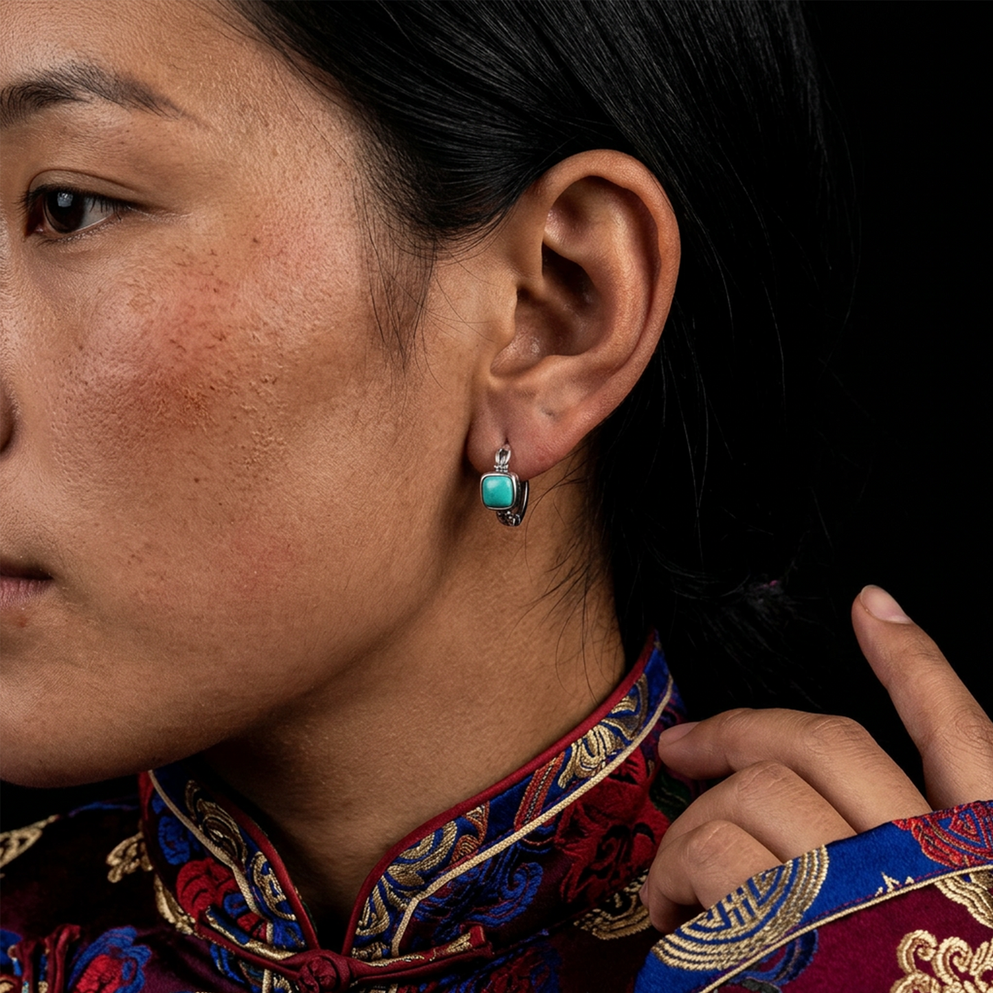 Close-up profile of a model wearing the geometric Tibetan turquoise huggie earrings for a sophisticated look.
