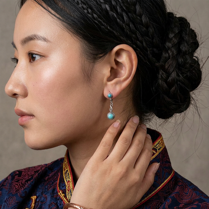 Close-up profile of a model wearing the Eternal Drops Tibetan turquoise earrings for spiritual wholeness.