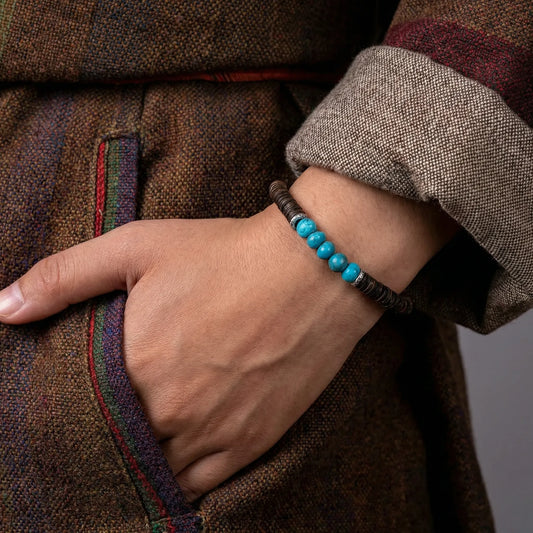 Close-up of a model's wrist with their hand in a pocket, wearing the organic turquoise disc bead bracelet.