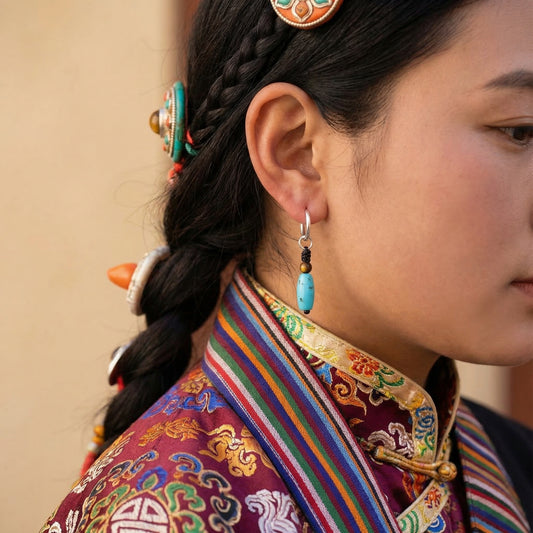 Close-up profile of a model wearing the Knot Drops Tibetan turquoise earrings for emotional resilience.