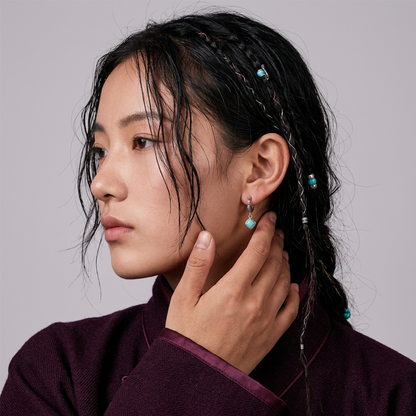 Close-up profile of a model wearing the Sentinel Drops Tibetan turquoise earrings for spiritual protection.