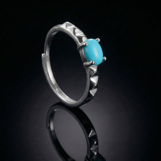The Ridge Ring featuring a vertical oval Tibetan turquoise and chevron-textured silver band.