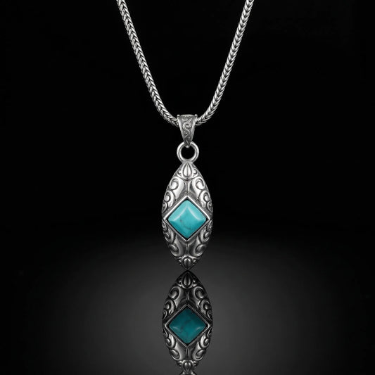 The Sentinel Crest Necklace featuring diamond-shaped Tibetan turquoise and oxidized silver scrollwork.