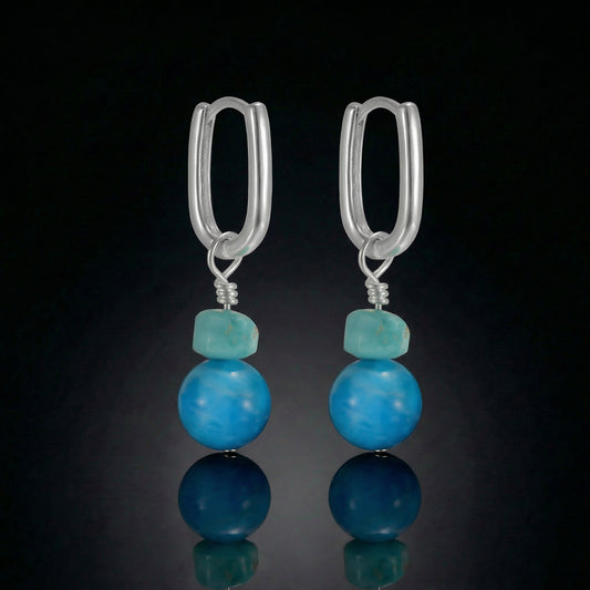 The Serene Drops featuring vibrant turquoise spheres and modern U-shaped sterling silver hoops.