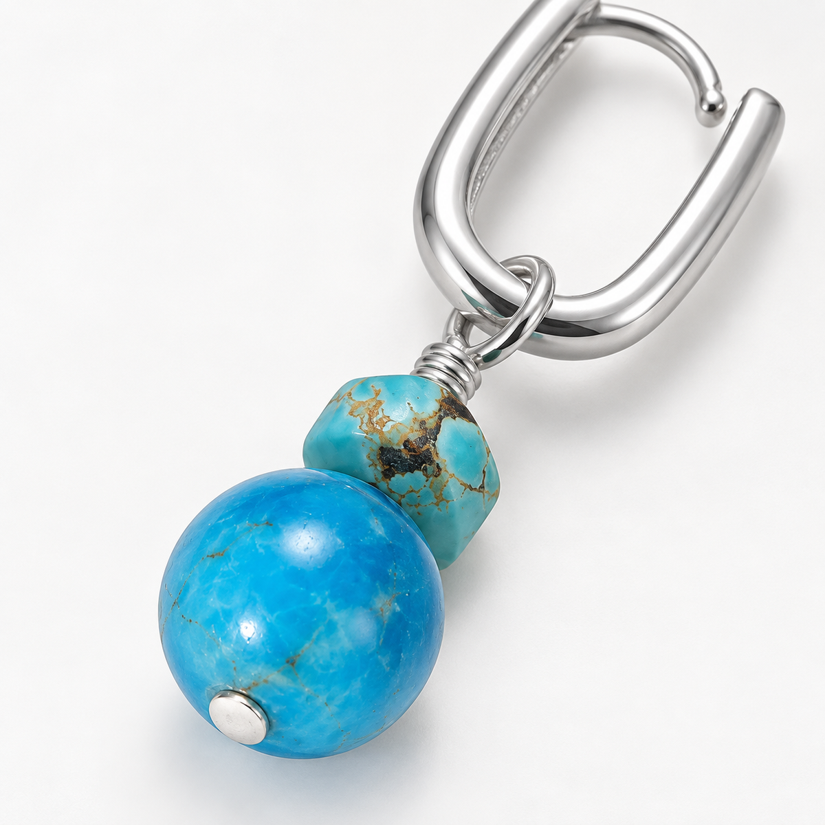 Close-up of Serene Drops turquoise sphere earring with sterling silver U-hoop and freeform turquoise accent