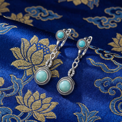 The Eternal Drops displayed on traditional blue silk with lotus motifs, reflecting Himalayan heritage and blessings.