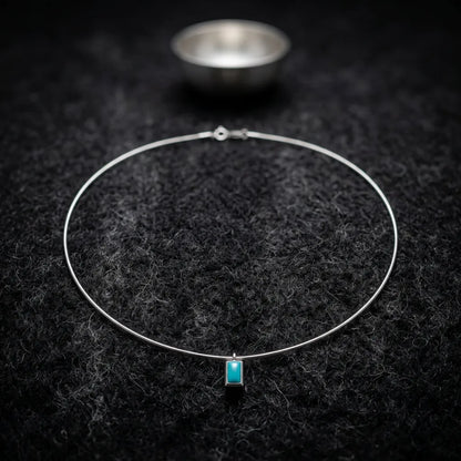 The Clarity Frame necklace displayed in a meditative setting with a silver bowl, reflecting Himalayan heritage.