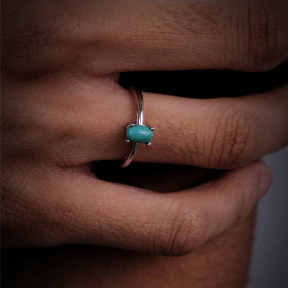 Profile view of the oval Tibetan turquoise ring on a finger, highlighting its low-profile minimalist design.
