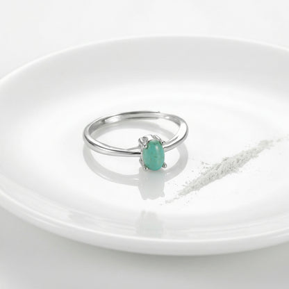 The Stillness Ring displayed on a white ceramic plate with a ritual powder line, reflecting purity and calm.