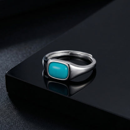 The Stillwater signet ring on a reflective black surface with atmospheric lighting, showcasing its clean lines.