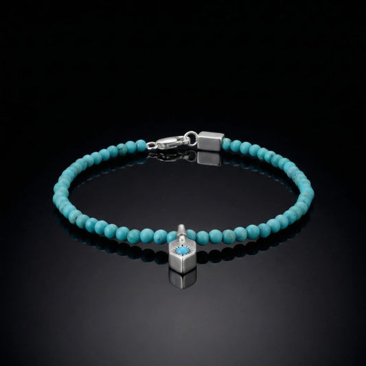 The Sun Shield Bracelet featuring vibrant round Tibetan turquoise beads and a silver sunburst shield charm.