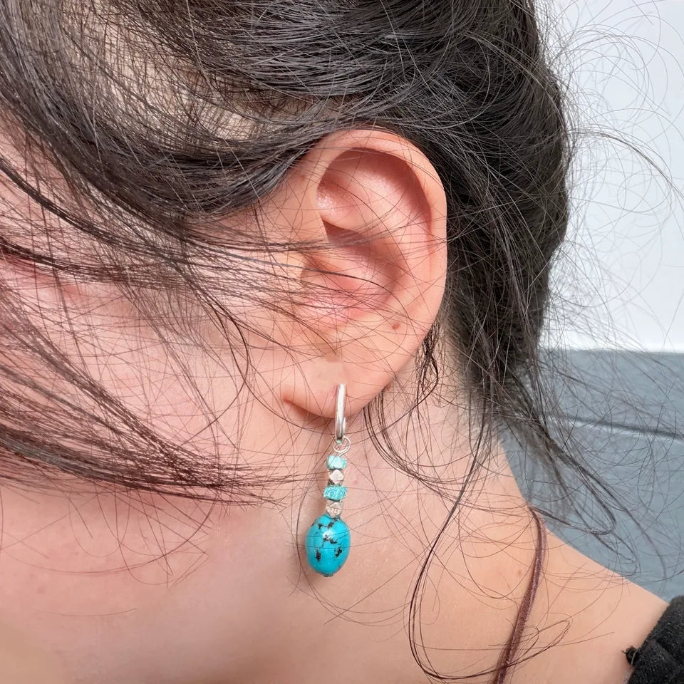 Customer wearing a turquoise and sterling silver drop earring