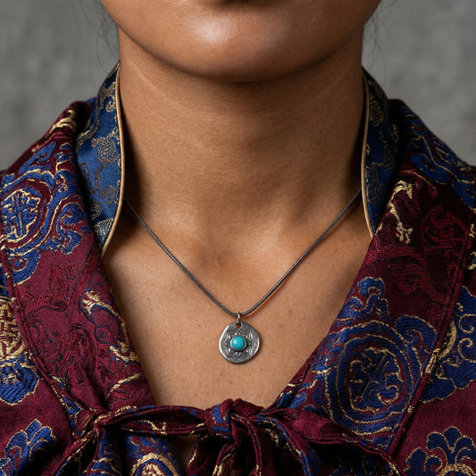 Model wearing the Tibetan turquoise shield necklace as a spiritual guardian talisman.
