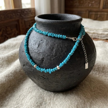 The Quiet Current choker displayed on a traditional black vase, reflecting Himalayan heritage.