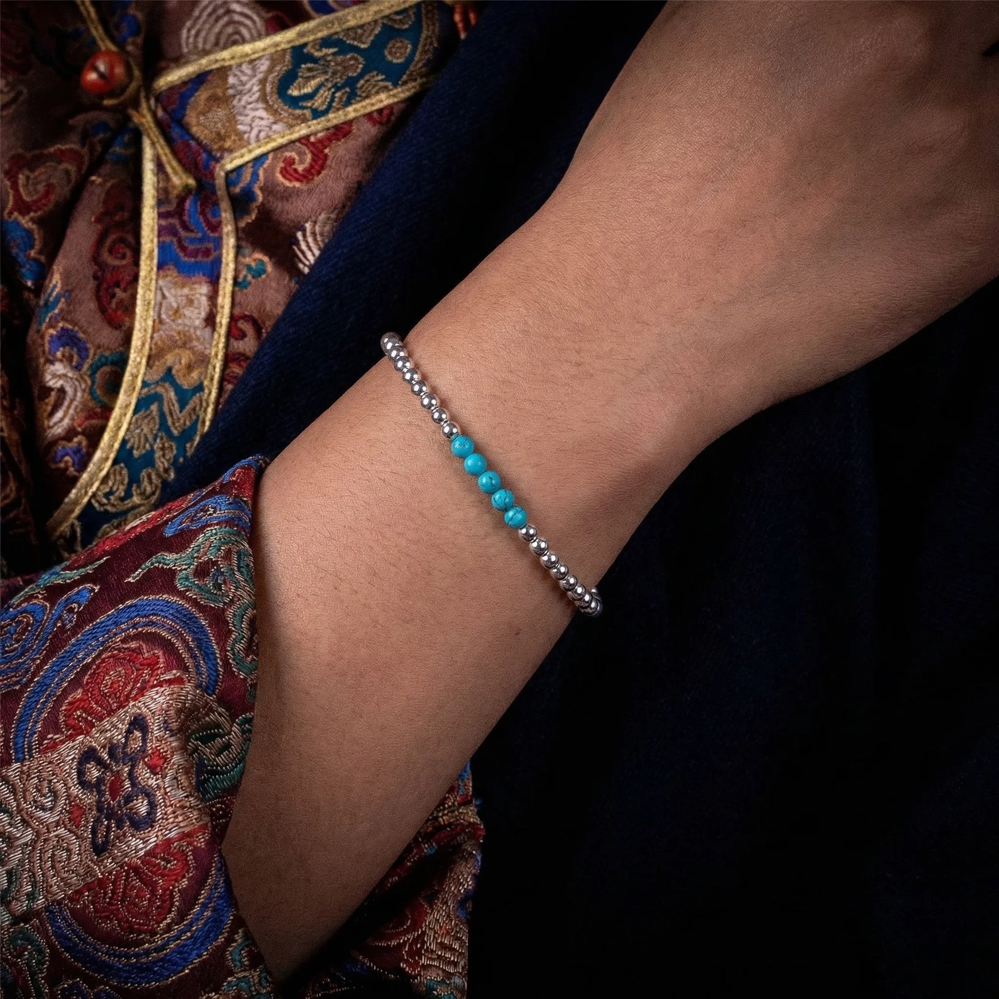 Side view of the Endless Loop turquoise bracelet on a wrist, showcasing the high-porcelain stones and silver beads.